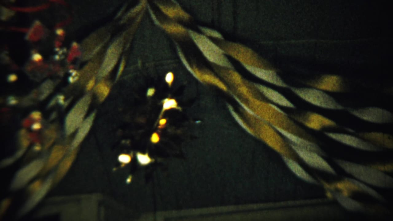 A close view of twisted garland and small lights hanging on a dark interior wall.