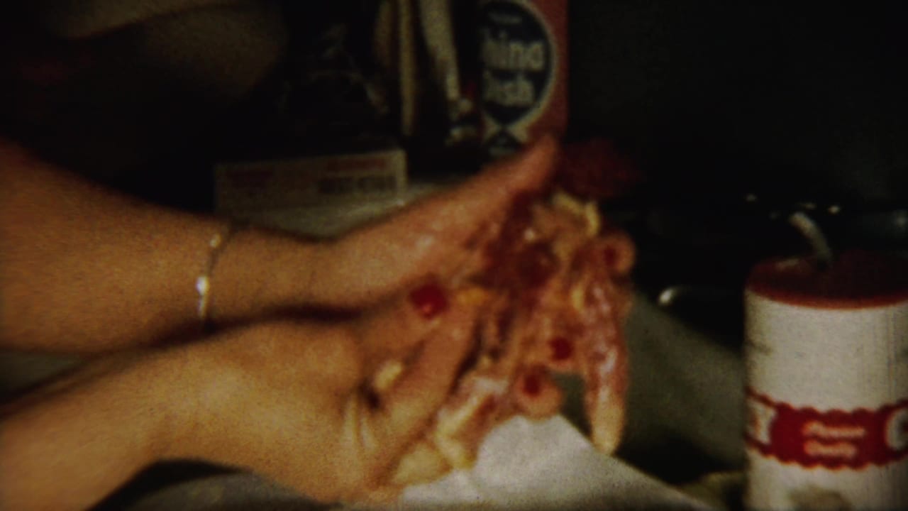 Close view of stained hands holding food residue near a dim kitchen counter.