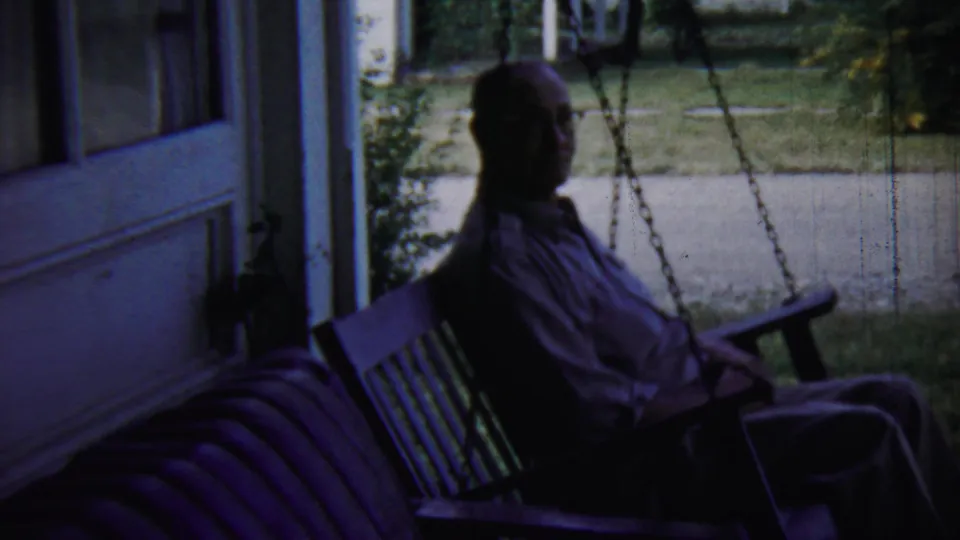A closer shaded frame shows the man seated on the porch swing, with the house edge, lawn, and sidewalk visible behind him.