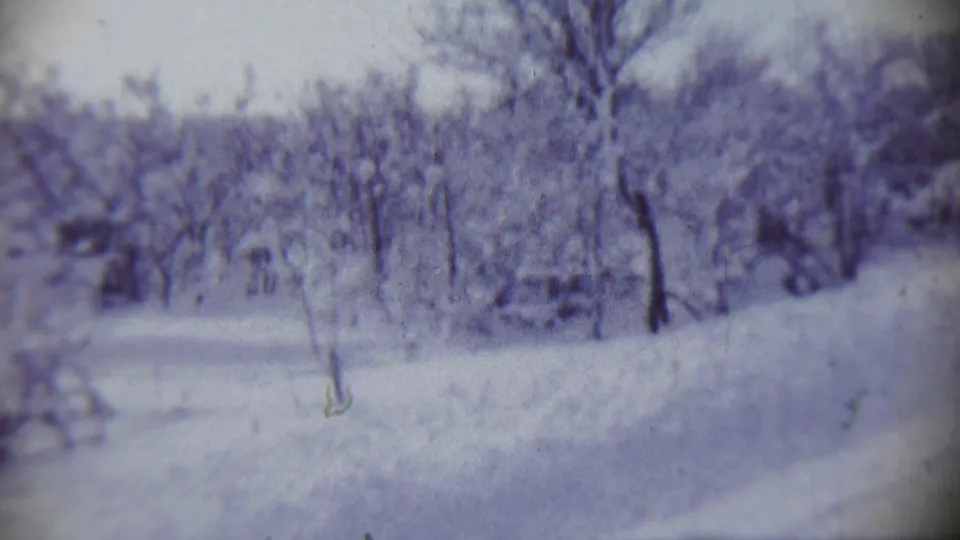 1959 Chadron, Nebraska winter view with bare trees, heavy snow cover, and small distant shapes softened by 8mm film texture.