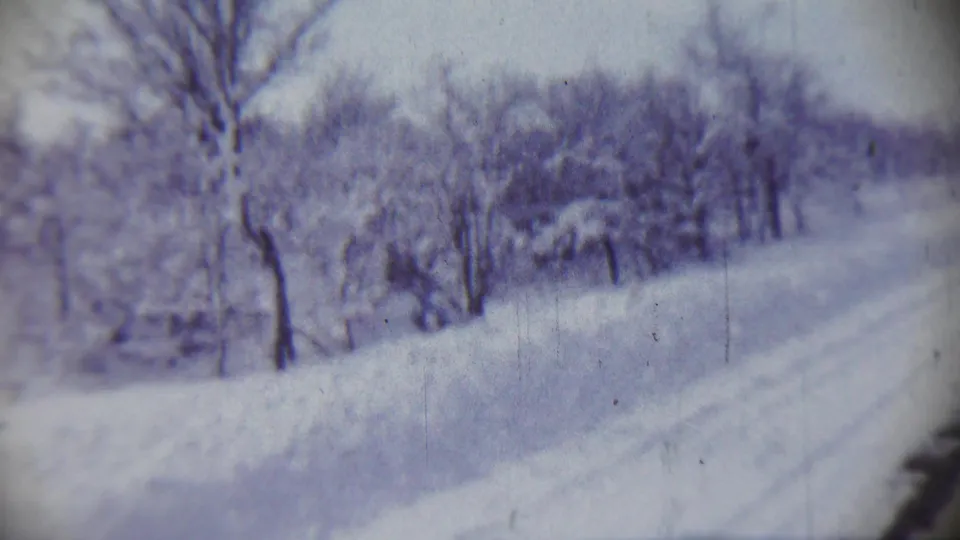 A soft 8mm frame shows a snow-covered roadside or path with bare trees in Chadron, Nebraska, dated by metadata to 1959.