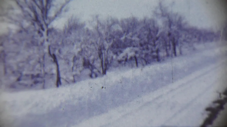 Final frame of the 1959 Chadron, Nebraska clip, with snow-covered ground, bare trees, and a quiet road or path receding through the scene.