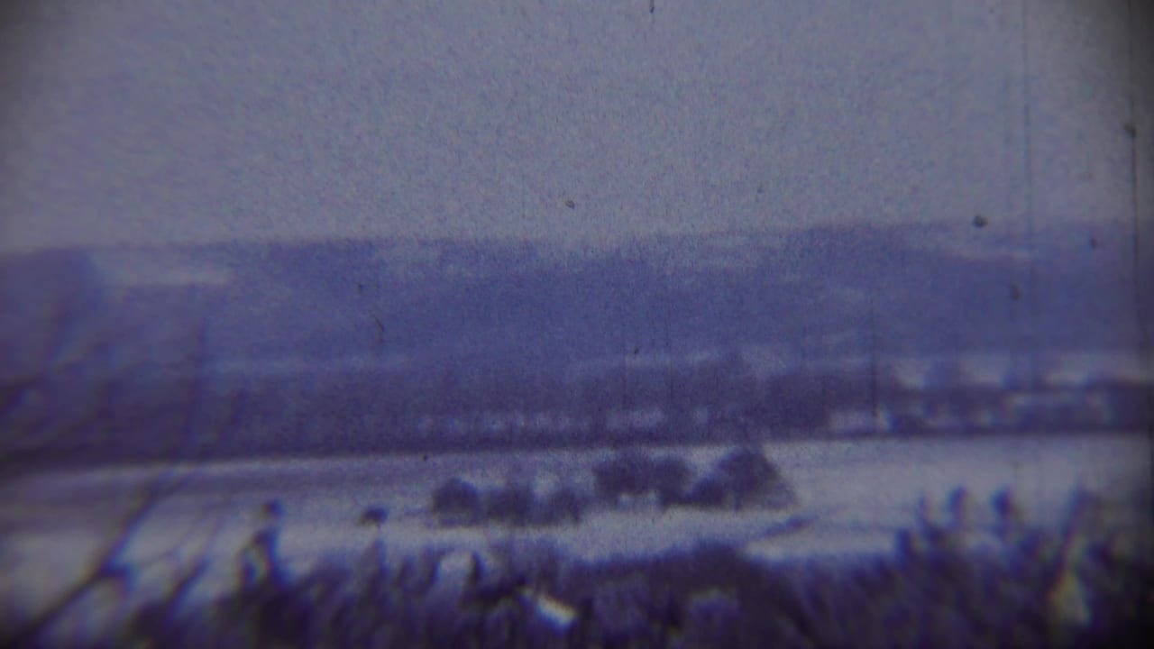 Distant snowy valley or field beneath a gray sky.