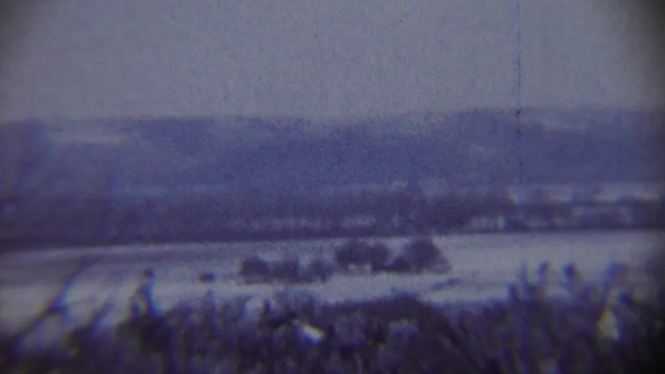 1959 Chadron, Nebraska 8mm frame showing a blurred snow-covered valley or field with low hills in the background.
