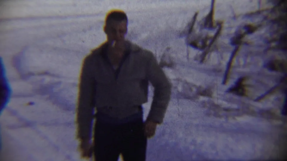 Adult man in a light jacket stands in snowy Chadron, Nebraska, with bare brush and uneven snow visible behind him.