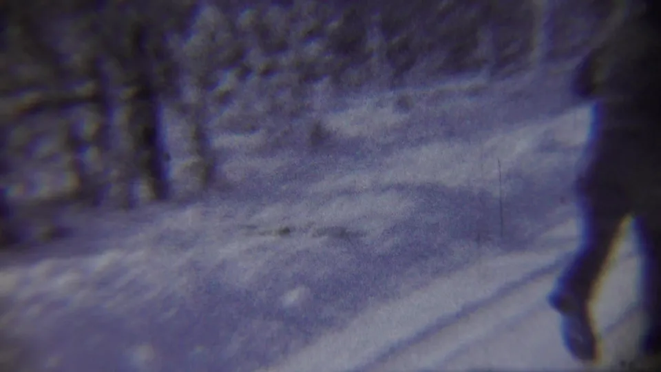 A child runs out of frame along a snowy Chadron road, with bare trees and snowbanks visible in the 1959 home-movie frame.