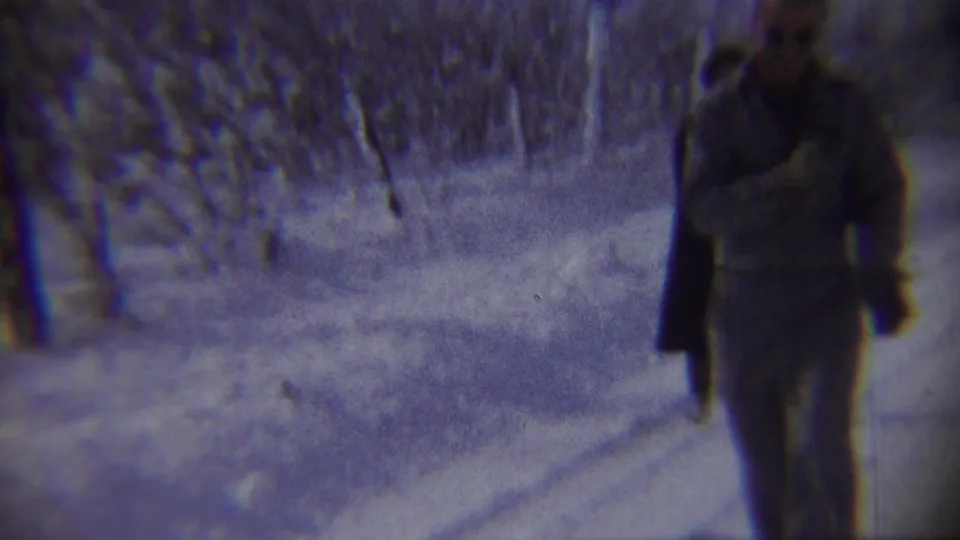 A man faces the snowy road in the foreground as a woman in a dark coat moves farther away in the 1959 Chadron scene.