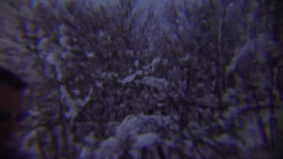 A partial figure appears at the left edge as the camera faces snow-covered trees in the 1959 Chadron winter scene.