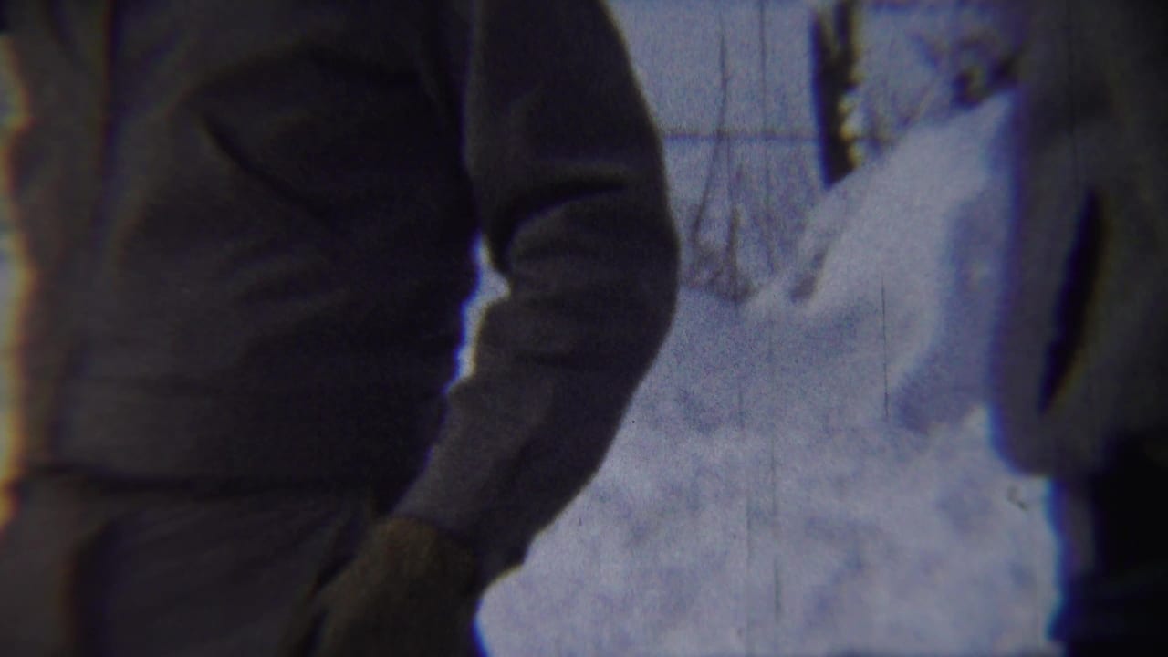 Bundled adult man partly framed beside deep snow on a winter street.