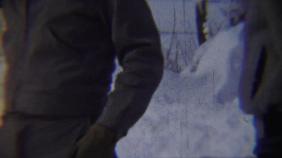 In Chadron, Nebraska, 1959 footage, a bundled adult man stands close to the camera beside deep snowbanks.