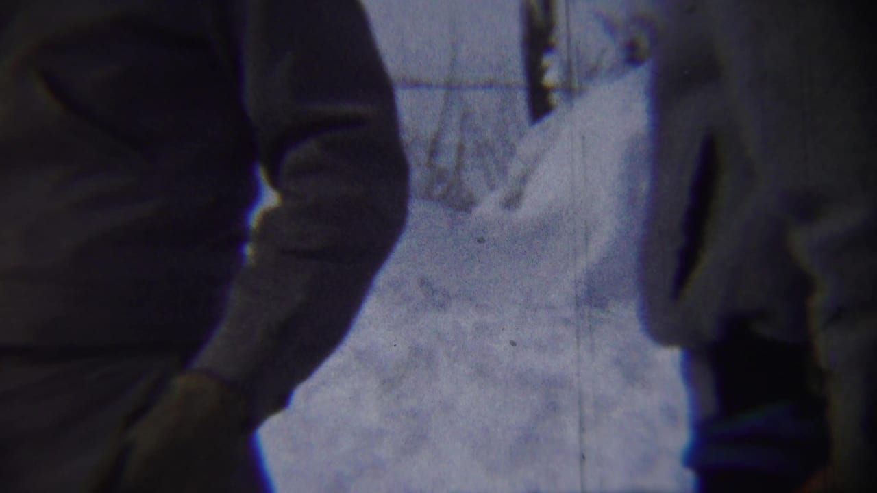 Two bundled adult men appear in a close 1959 Chadron winter street view with deep snow behind them.