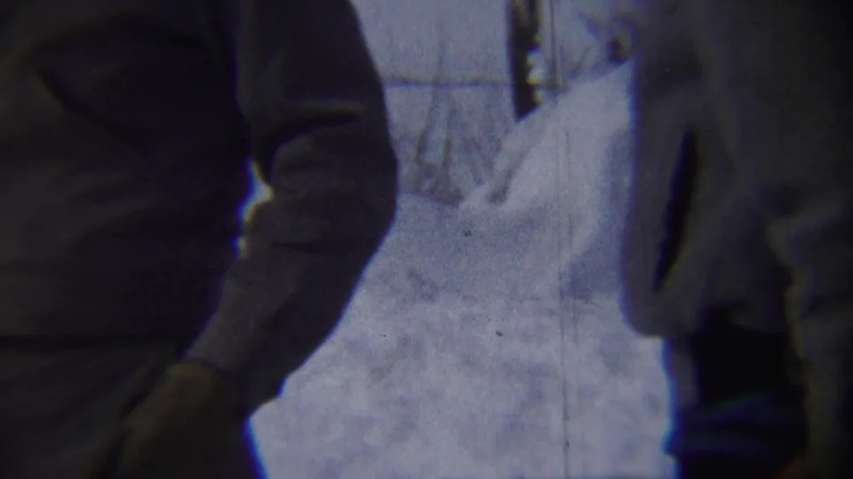 Two bundled adult men appear in a close 1959 Chadron winter street view with deep snow behind them.
