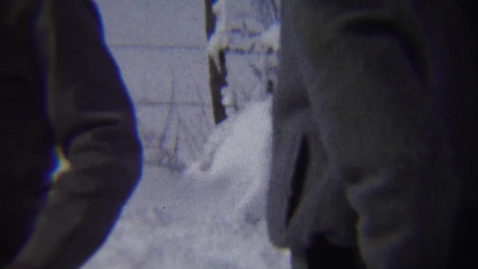 In Chadron, Nebraska home-movie footage from 1959, two bundled figures stand close to the camera beside deep snow.