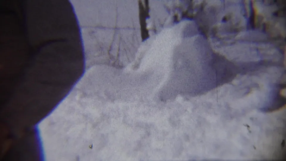 A bundled adult stands beside a rounded snow mound in an outdoor winter scene, identified by metadata as Chadron, Nebraska in 1959.