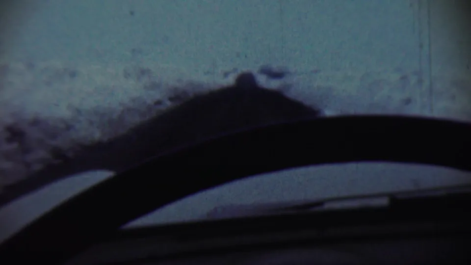 Final frame of the 1959 Chadron winter view, with snow beyond the windshield and a silhouetted dashboard or steering-wheel edge.