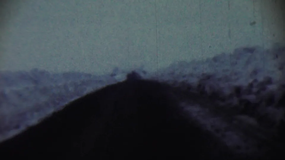 Final 1959 Chadron, Nebraska frame showing a shadowed vehicle POV through rural terrain with visible 8mm film wear.