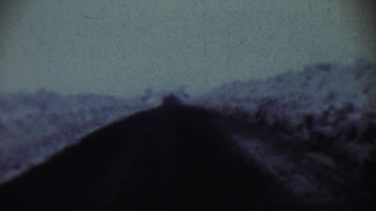 1959 Chadron, Nebraska home-movie frame showing heavy snow piled near a residential house, with part of the facade visible.