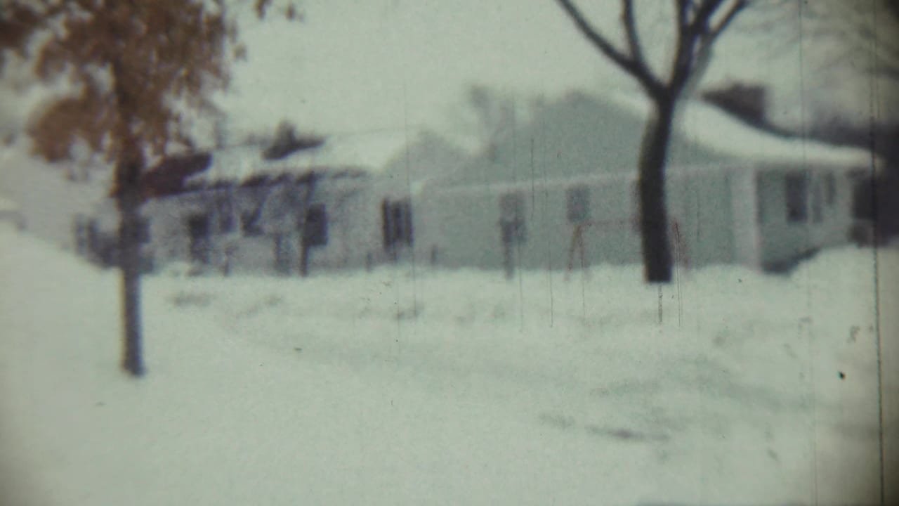 1959 Chadron, Nebraska 8mm frame showing snow-covered houses, bare trees, and a pale winter sky.