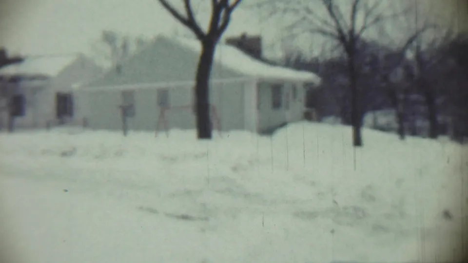 1959 Chadron, Nebraska frame with a snow-covered one-story house, bare trees, and a simple swing set.