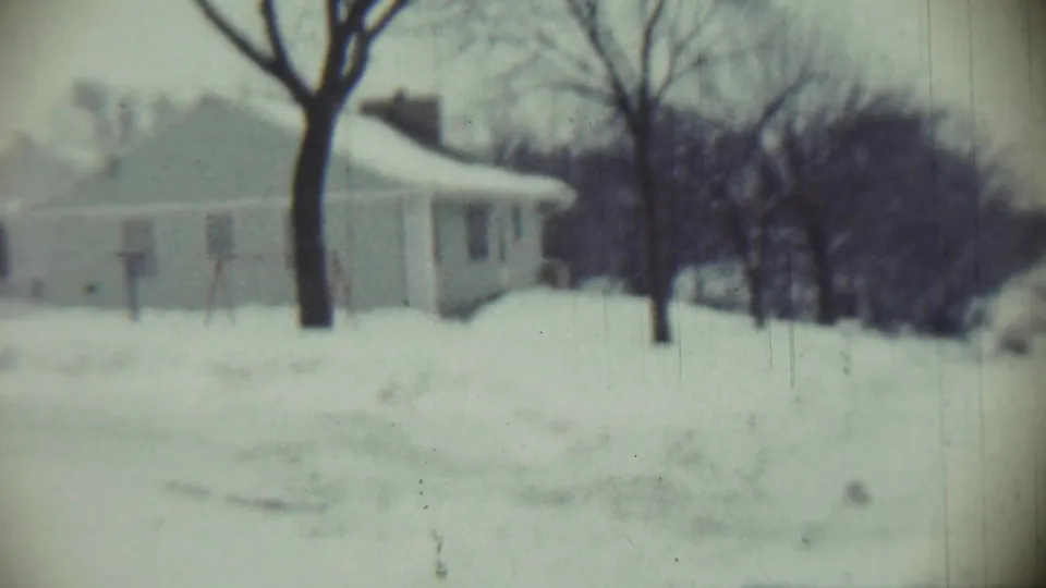 Chadron, Nebraska winter frame from 1959 showing a house beyond a snow-covered yard and bare trees.