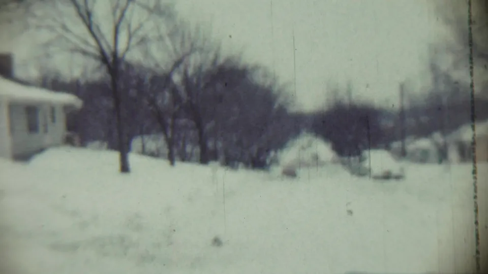 1959 Chadron, Nebraska view across a snow-blanketed neighborhood with bare trees and low houses partly obscured by drifts.