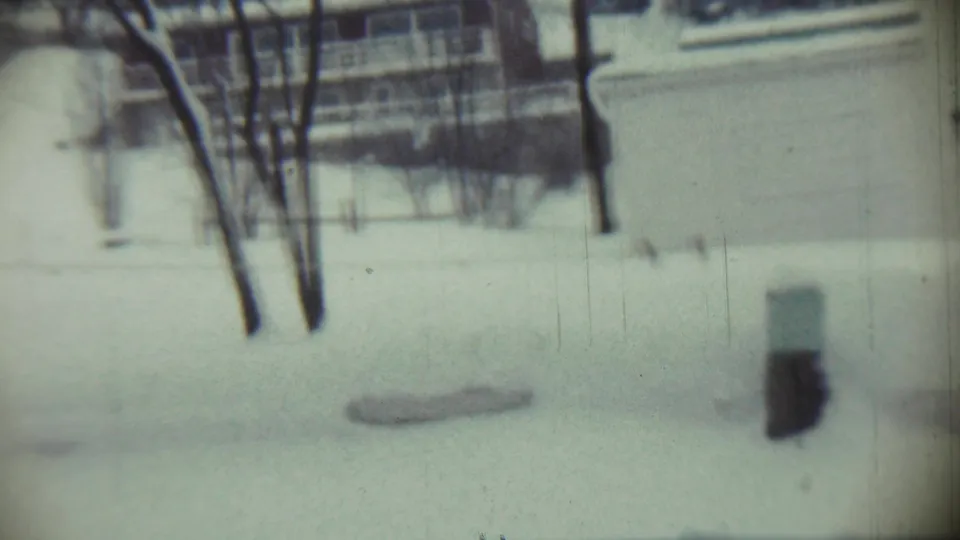 A static 1959 Chadron winter yard view shows snow, leafless trees, a background building, and a dark upright object at right.