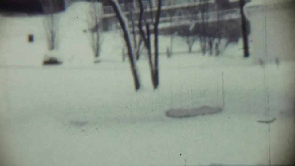 The final Chadron winter frame shows the snowy yard, bare trees, a distant building, and a thin wire or string near the snow.