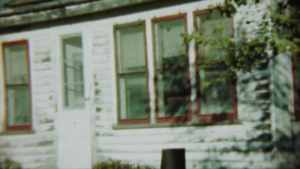 1959 Chadron, Nebraska frame showing the house exterior from a similar angle, with branches partly crossing the view.