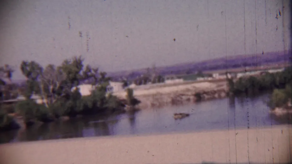 Cheyenne County, Kansas river landscape on 8mm film, with trees along the water and low hills in the distance.