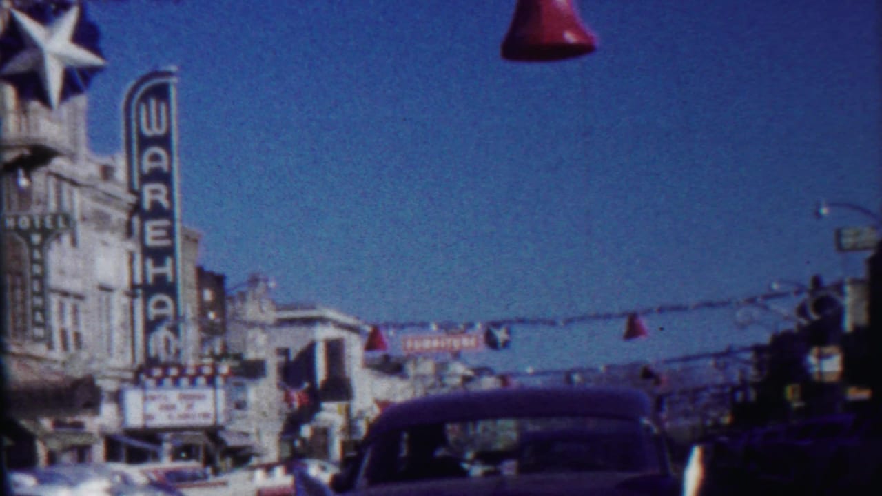 Street decorations hang above cars near the Wareham theater and hotel signs.