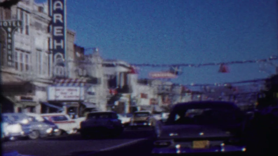 1959 Saint Francis street scene showing the rear of a classic car, the Wareham sign, storefronts, and overhead festive decorations.