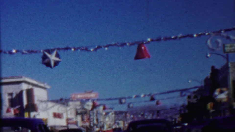 Saint Francis, Kansas street scene with a star ornament, red streamer decorations, storefront signage, and cars in traffic.