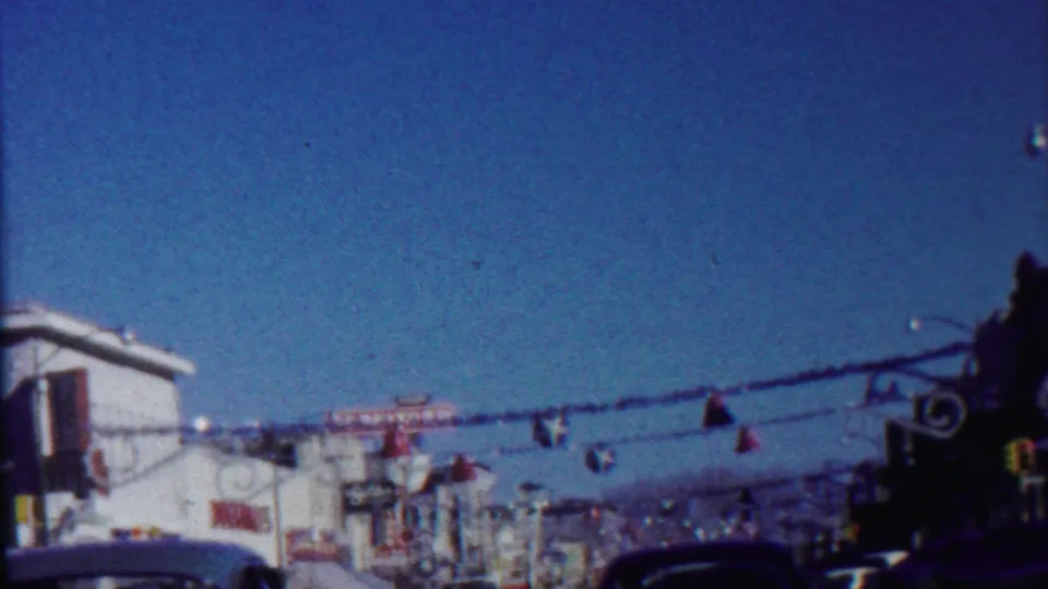 Decorated Saint Francis, Kansas roadway in 1959, showing streamers, storefronts, traffic signals, cars, and a broad blue sky.