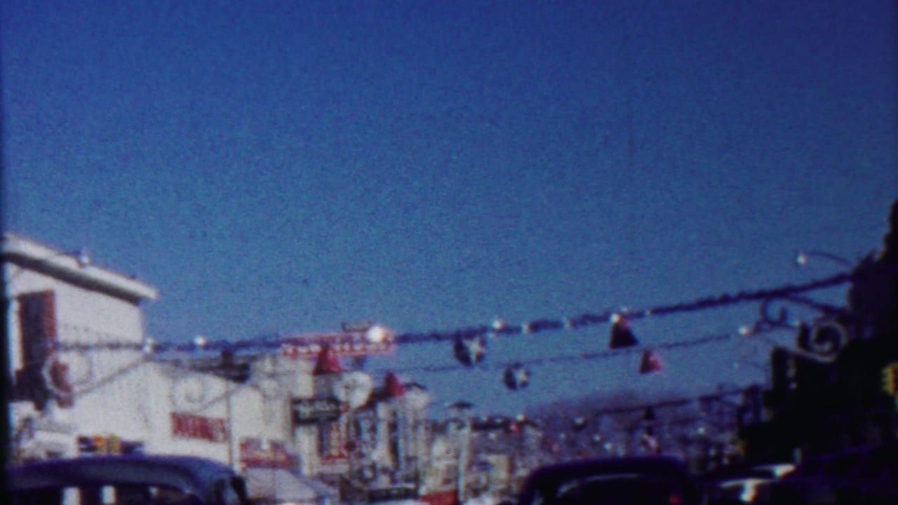 Saint Francis, Kansas street scene from 1959 with overhead festive decorations, storefront signage, and parked vintage cars.