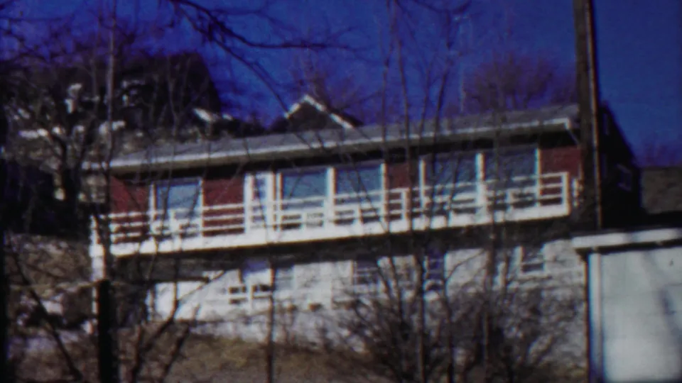 Saint Francis, Kansas apartment exterior on 8mm film, with a long white balcony and leafless trees crossing the frame.