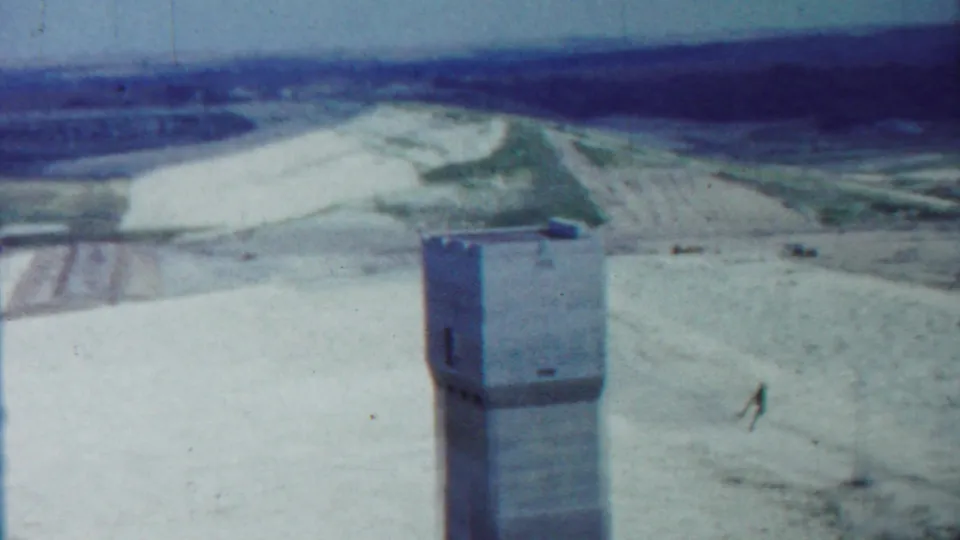 1959 Saint Francis, Kansas 8mm frame showing a concrete tower in an open sandy plains landscape with distant fields.