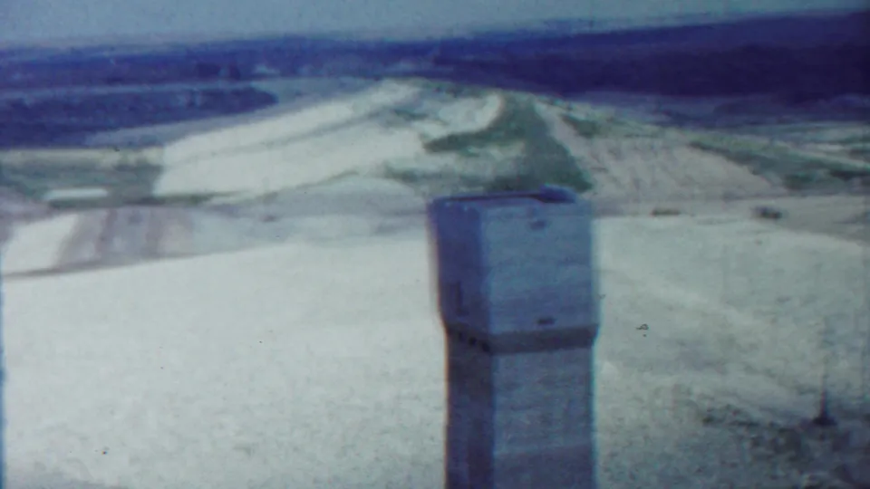 Saint Francis, Kansas archival frame showing the concrete tower in front of sandy terrain and distant cultivated land.