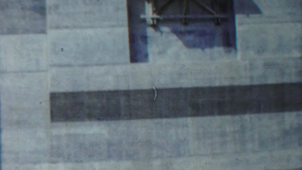 Concrete building detail in Saint Francis, Kansas, with a raised platform, dark horizontal opening, and weathered 8mm color.