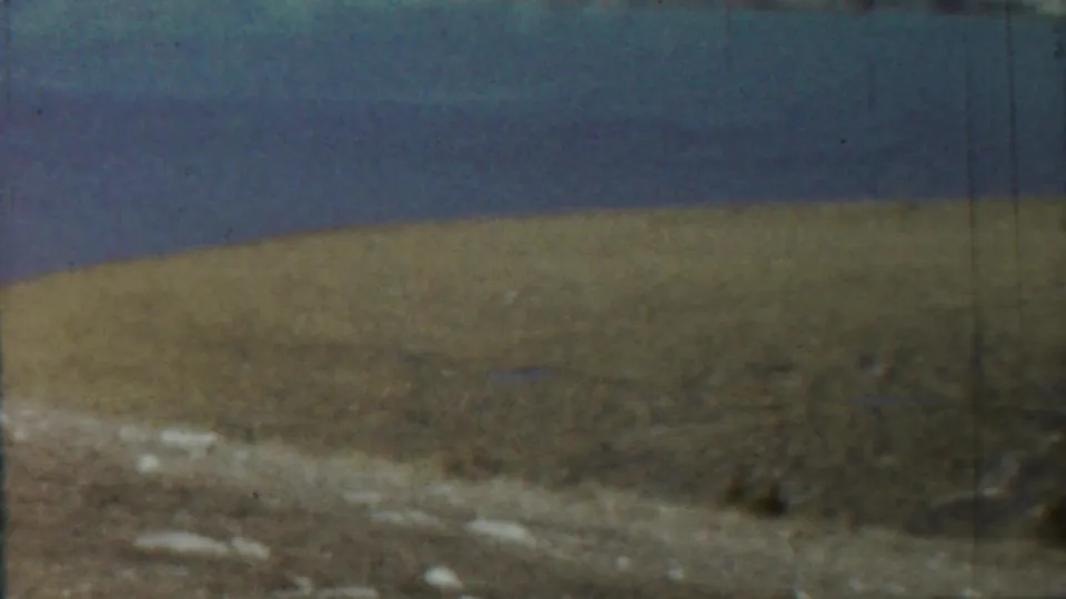 1959 8mm frame associated with Saint Francis, Kansas, showing calm water and a distant shoreline with faded color and grain.