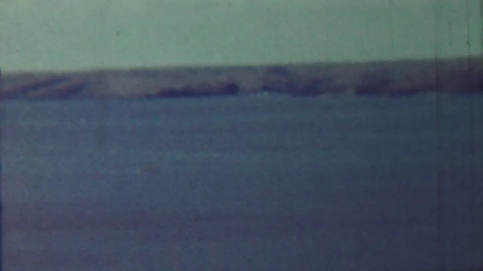 1959 Saint Francis, Kansas home-movie frame showing calm open water, pale sky, and a soft distant shoreline.