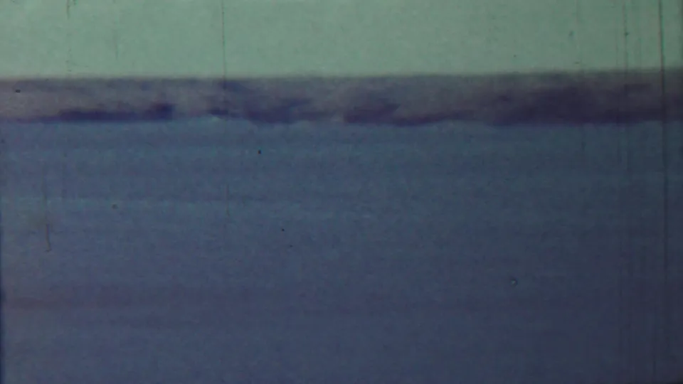 1959 Saint Francis, Kansas frame showing a wide calm waterscape, distant shore, and visible 8mm film wear.