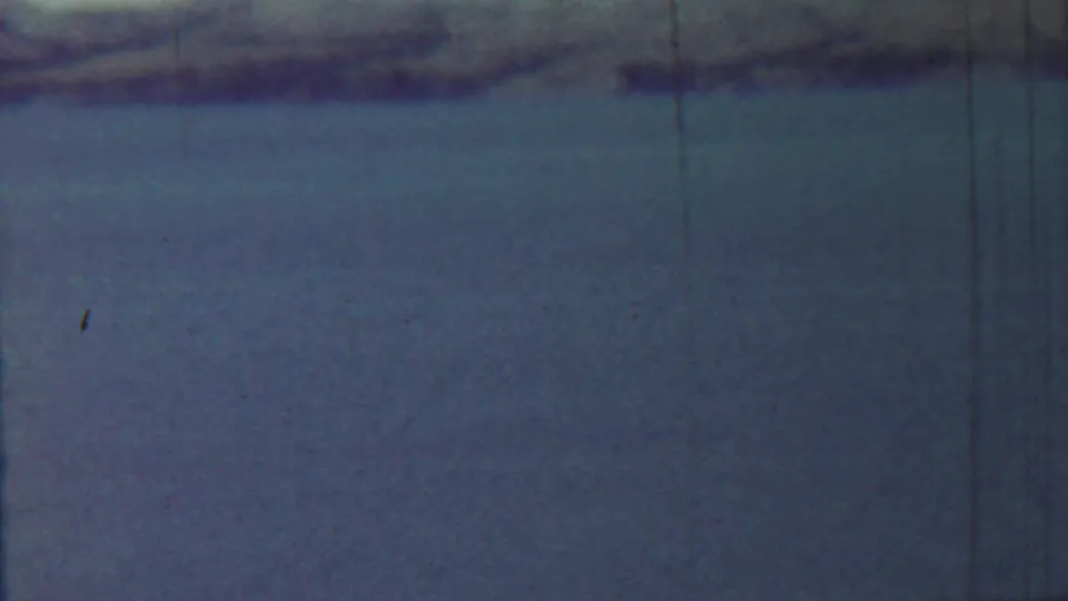 Final frame of the 1959 Kansas water pan, showing blue-green water, a soft shoreline, and pronounced vertical film wear.