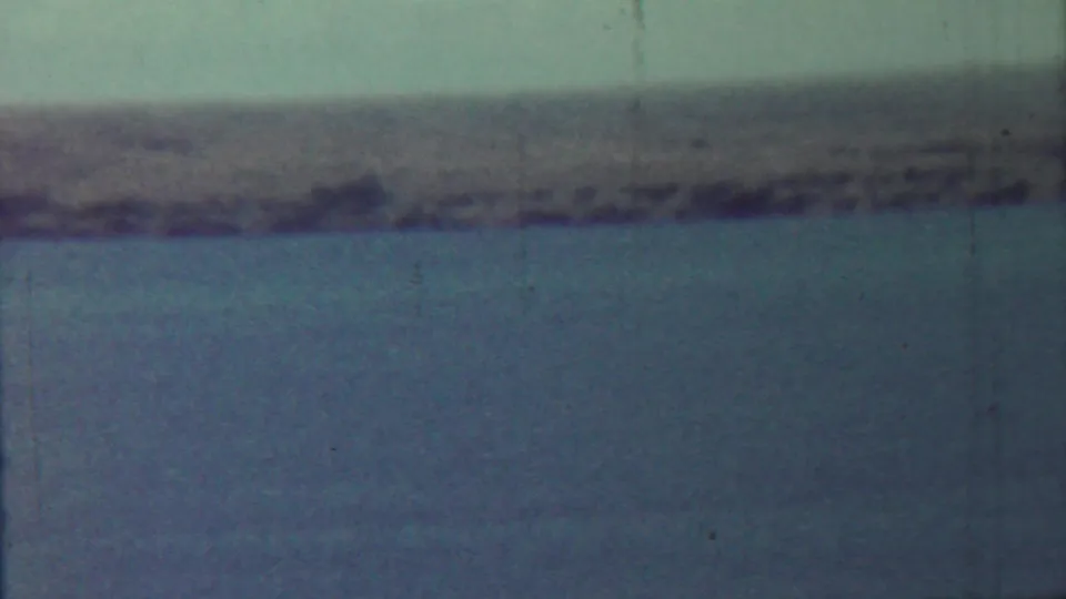 1959 Saint Francis, Kansas river landscape showing calm water, a distant shore, pale sky, and aged 8mm texture.