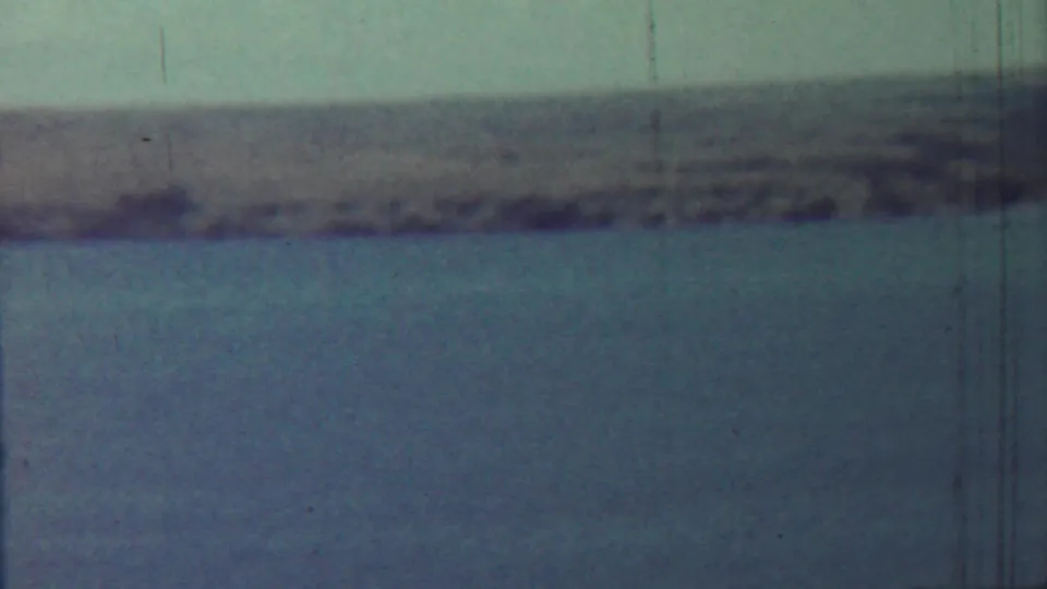1959 8mm home-movie frame from the Saint Francis, Kansas metadata showing calm water and a blurred far shoreline.