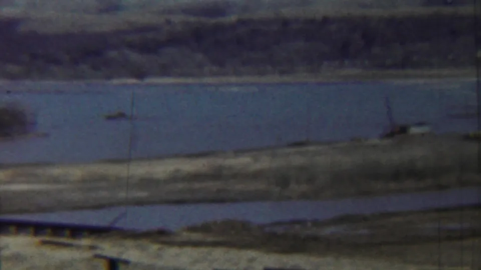 1959 Saint Francis, Kansas riverside view with a small boat on the water and a low shoreline beyond.