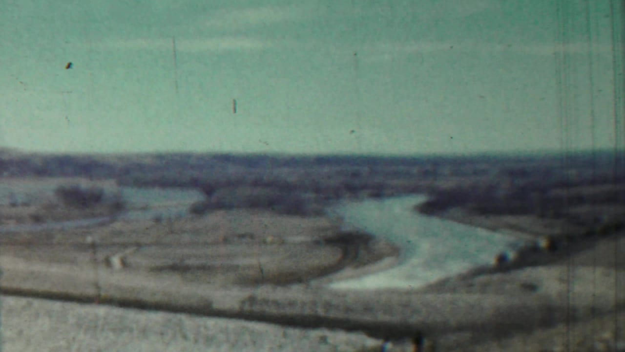 1959 Saint Francis, Kansas home-movie frame showing a winding river across open rural terrain with a distant low horizon.