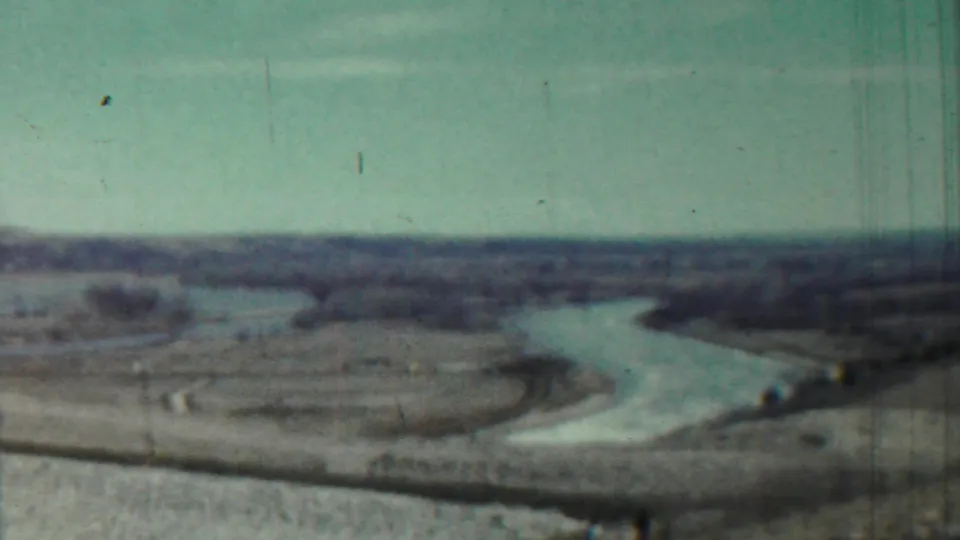 1959 Saint Francis, Kansas home-movie frame showing a winding river across open rural terrain with a distant low horizon.
