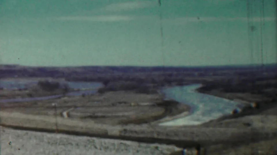 Saint Francis, Kansas landscape frame with a pale river channel, low banks, and open rural ground in soft 8mm color.
