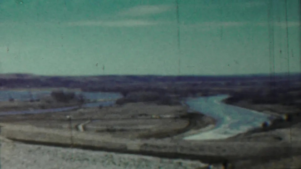 Final frame holds on the winding watercourse and flat rural Kansas terrain, with visible grain and age-related color shift.