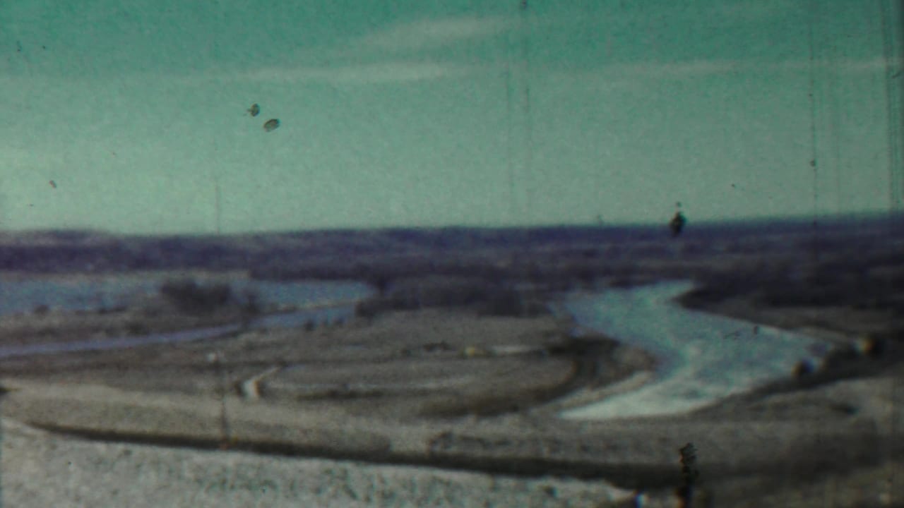 Distant river bend across open countryside with film scratches visible.